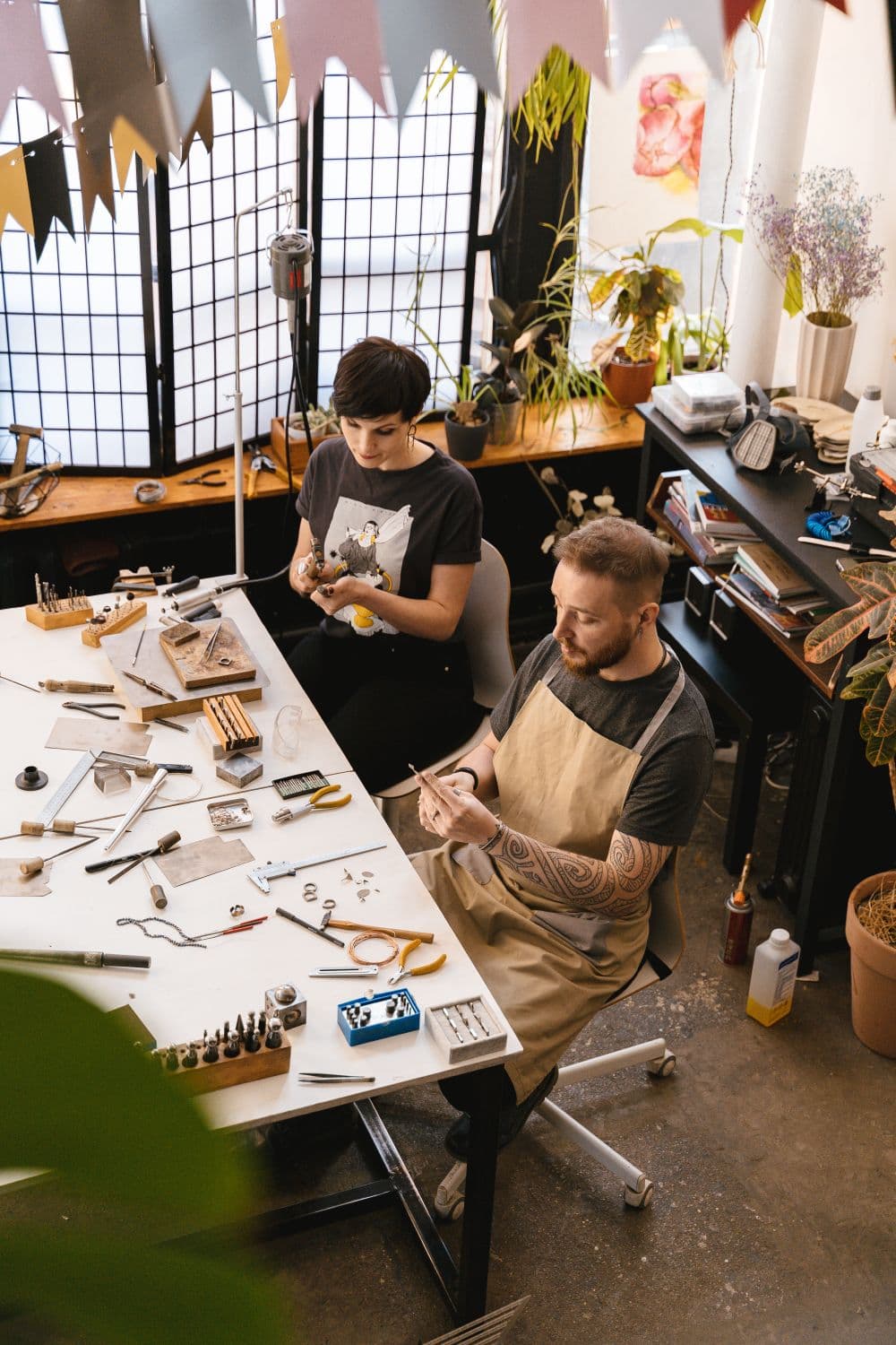 Two artisans working together at a workshop bench